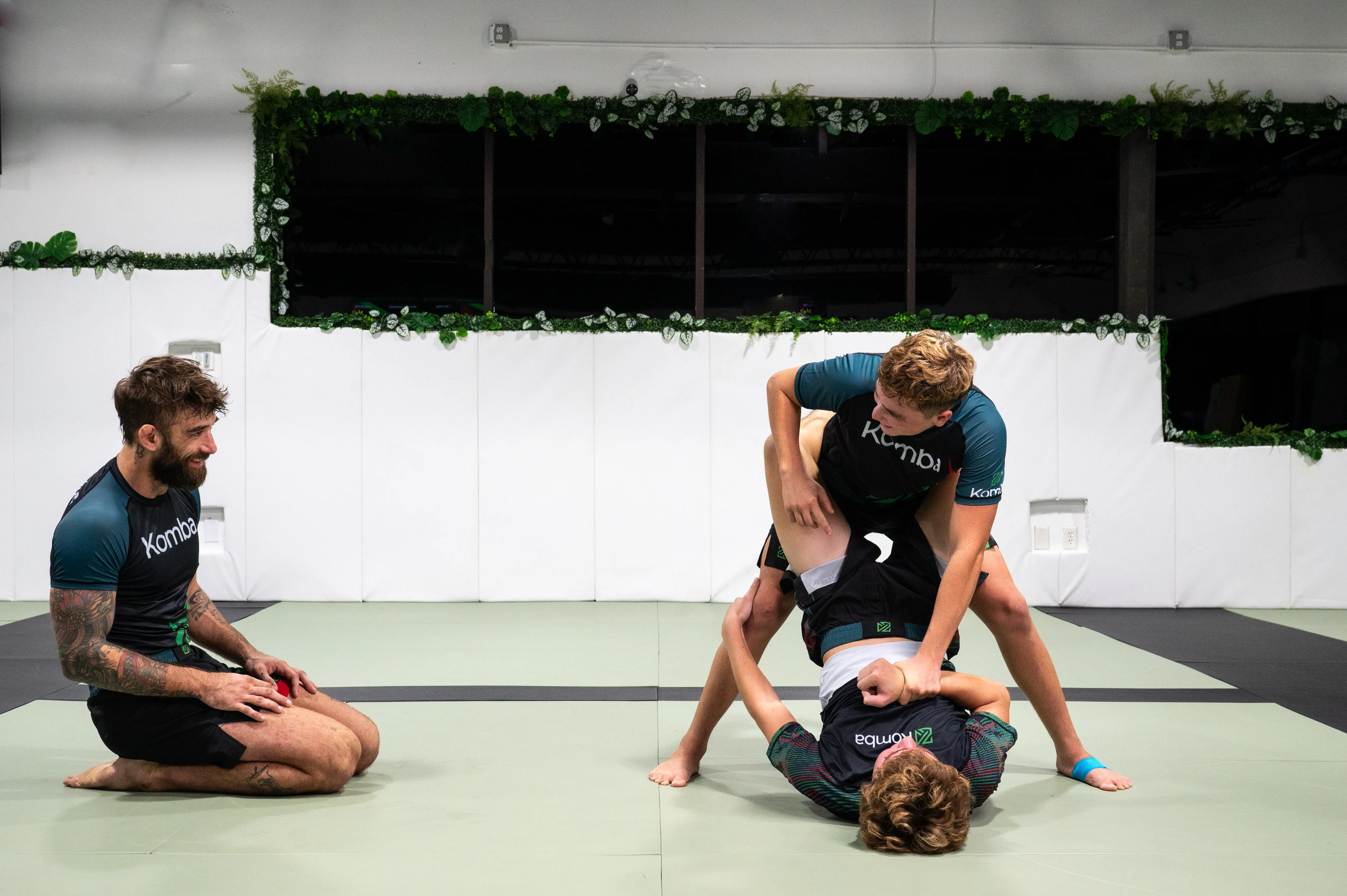 Coach Alex working with young grapplers on the mat
